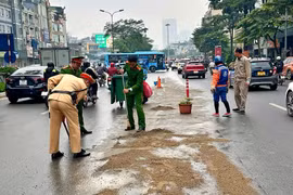 Kịp thời xử lý vết dầu loang trên phố Hà Nội khi trời đang mưa 