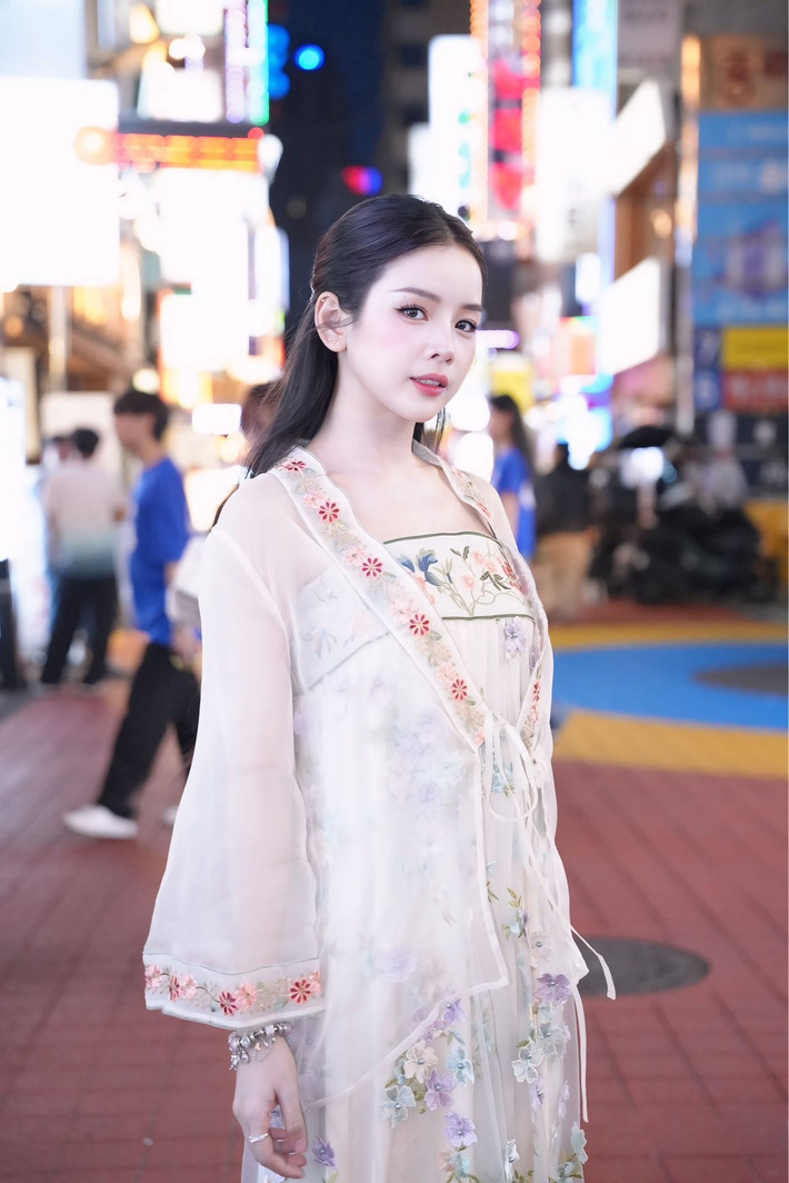 Điểm nhấn làm nên vẻ "tiểu thư" của Mie chính là mái tóc đen dài được buộc nửa đầu gọn gàng, tôn lên gương mặt thanh tú, cùng lối trang điểm nhẹ nhàng, trong trẻo. Cô nàng còn khéo léo phối hợp với phụ kiện là chiếc túi xách Dior màu hồng pastel nữ tính, mang đến một tổng thể hài hòa và sang trọng.