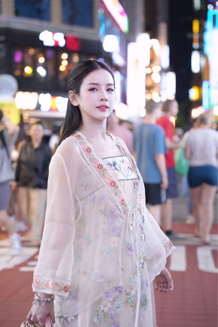 Trong loạt ảnh mới được chia sẻ, DJ Mie khoác lên mình một bộ trang phục bay bổng và tinh tế. Cô nàng chọn chiếc áo khoác ngoài xuyên thấu, nhẹ nhàng, với họa tiết hoa thêu tinh xảo chạy dọc thân áo và tay áo. Set đồ gợi đến trang phục truyền thống của phụ nữ Hàn Quốc.