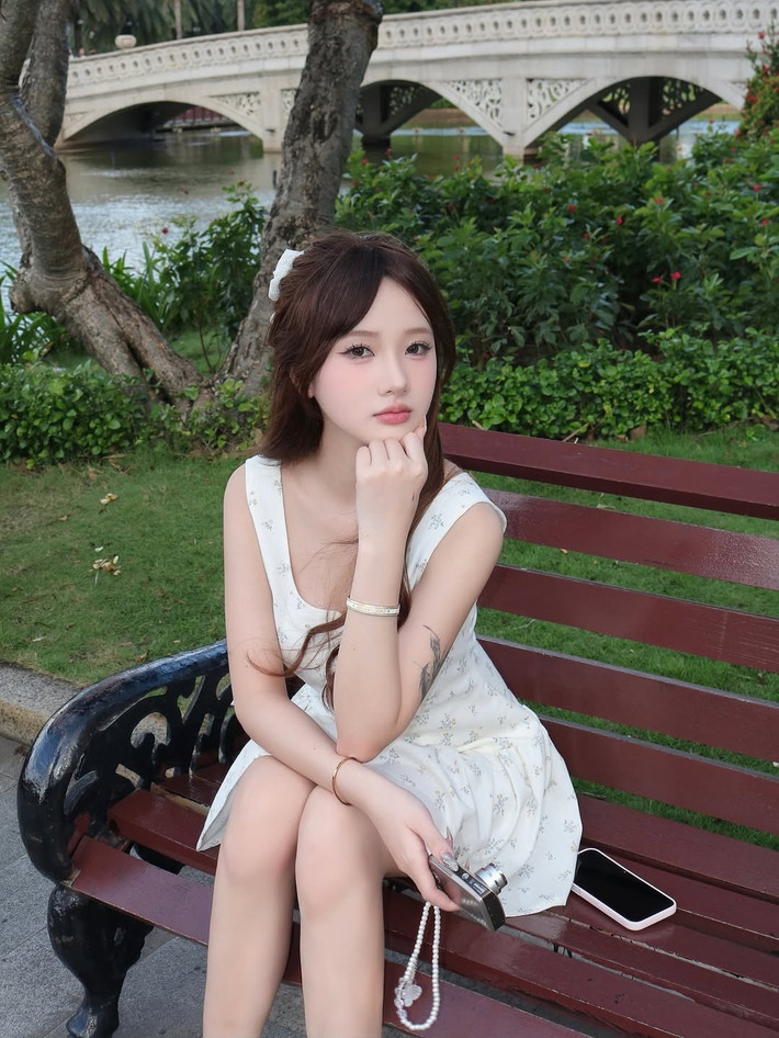 Trong những bức hình, Diệu Linh chọn cho mình một chiếc váy liền thân màu trắng tinh khôi, với họa tiết hoa nhỏ li ti điểm xuyết nhẹ nhàng.