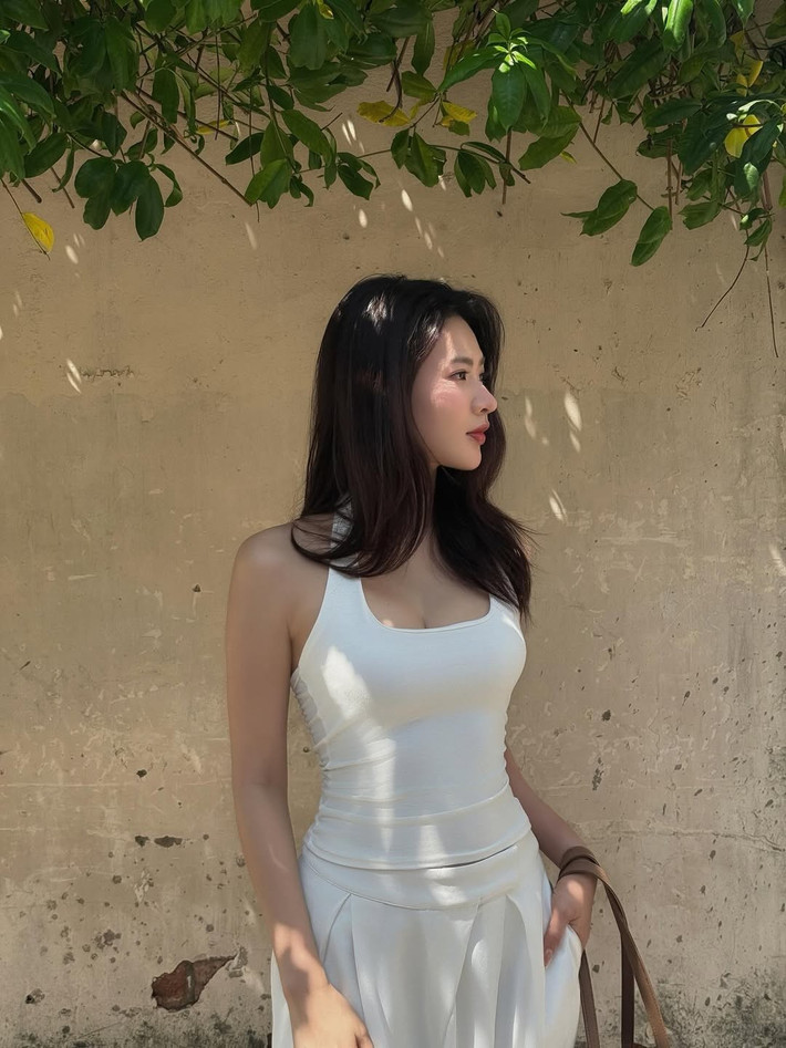 Trong loạt ảnh được đăng tải, Minh Trang diện trang phục toàn bộ màu trắng, bao gồm một chiếc áo hai dây tôn lên bờ vai thon thả và chiếc quần ống rộng với phần cạp được xếp ly điệu đà tôn dáng. (Ảnh: IGNV)