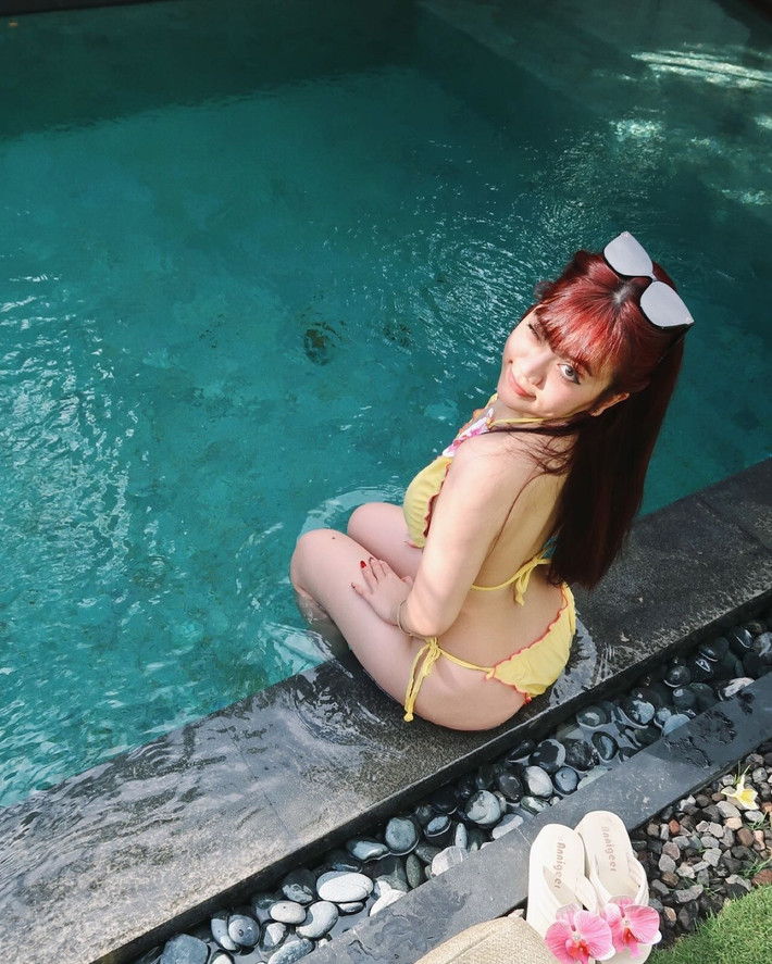 Trong bộ ảnh mới, Bảo Hân lựa chọn bộ bikini vàng rực rỡ, điểm xuyết hoa lan hồng nổi bật trên phần ngực và hông, tôn lên đường cong cơ thể đầy quyến rũ.