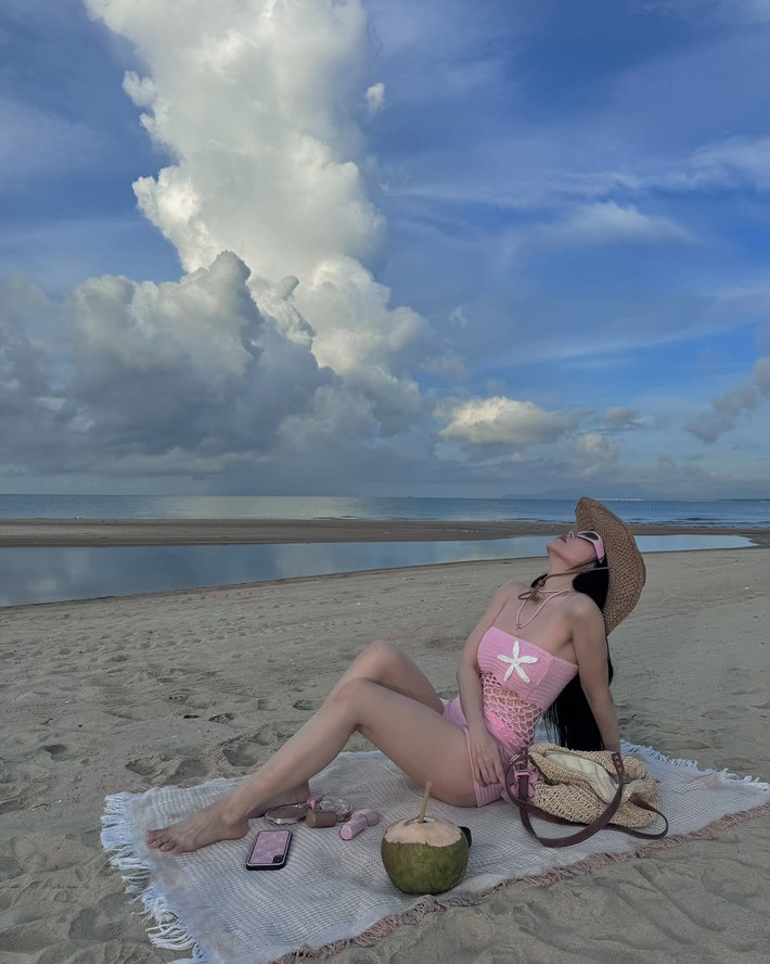 Không dừng lại ở đó, Sĩ Thanh hoàn thiện tổng thể bằng phụ kiện cá tính như kính râm bản to, vòng cổ handmade túi cói tone nâu be – tạo nên phong cách beachwear đầy phóng khoáng và thời thượng.