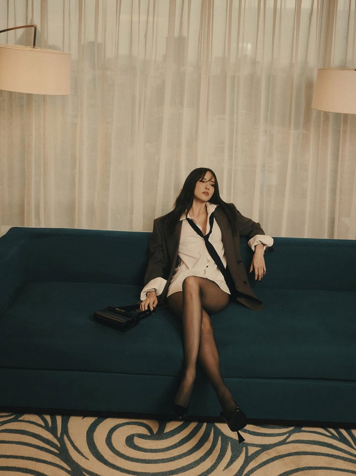Trong bộ ảnh, Thiều Bảo Trâm diện một chiếc áo sơ mi trắng dáng rộng kết hợp cùng blazer màu nâu đất phóng khoáng và cà vạt buông lơi, tạo nên vẻ ngoài vừa lịch lãm, vừa phá cách.