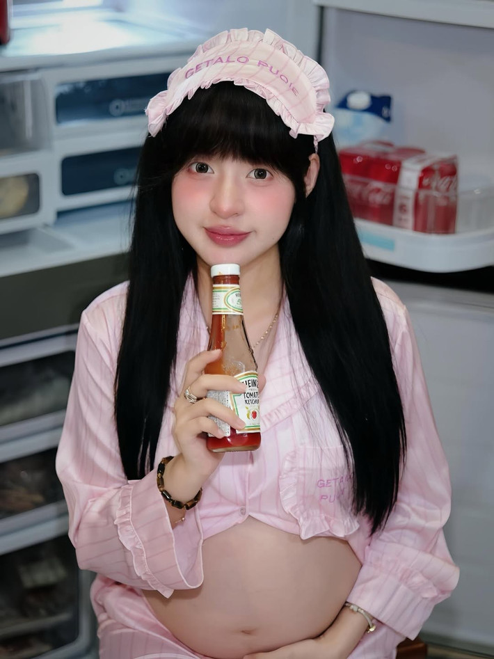 Trong bộ pijama hồng pastel thoải mái, điểm xuyết họa tiết kẻ sọc nhẹ nhàng, Trần Thanh Tâm toát lên vẻ dịu dàng và nữ tính của một người sắp làm mẹ.
