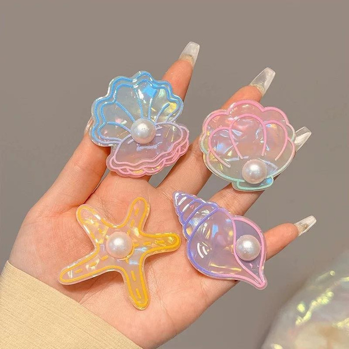 Không chỉ là hình dáng, các chi tiết đính kết như ngọc trai, hạt cườm, hoặc đá lấp lánh cũng là điểm nhấn quan trọng, biến những chiếc kẹp tóc đơn giản trở nên nổi bật và thu hút hơn.