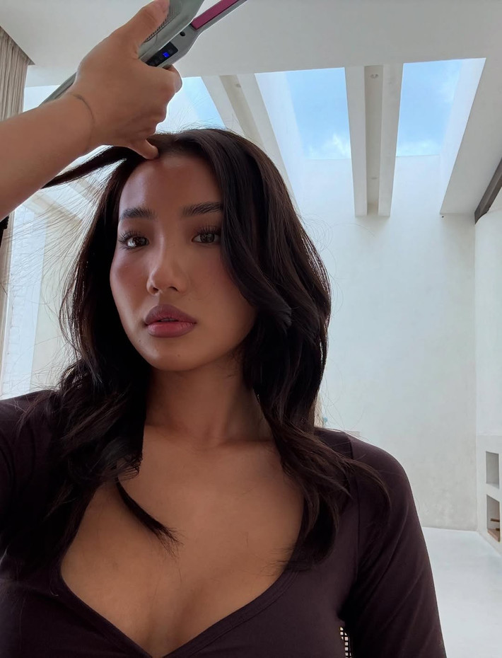 Lối trang điểm theo hướng phương Tây với sự nhấn nhá vào phần mắt, màu son nude cùng má hồng ửng tự nhiên tạo nên tổng thể gợi cảm.