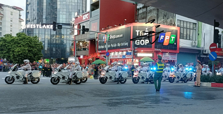 Đoàn xe cảnh sát đi qua trong sự chào đón nồng nhiệt của đông đảo người dân.