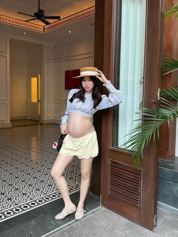 Nổi bật trong loạt ảnh đi du lịch gần đây là set đồ gồm chiếc áo croptop sọc ngang kết hợp với chân váy ngắn ren, để lộ bụng bầu một cách tự nhiên và đáng yêu. (Ảnh: IGNV)