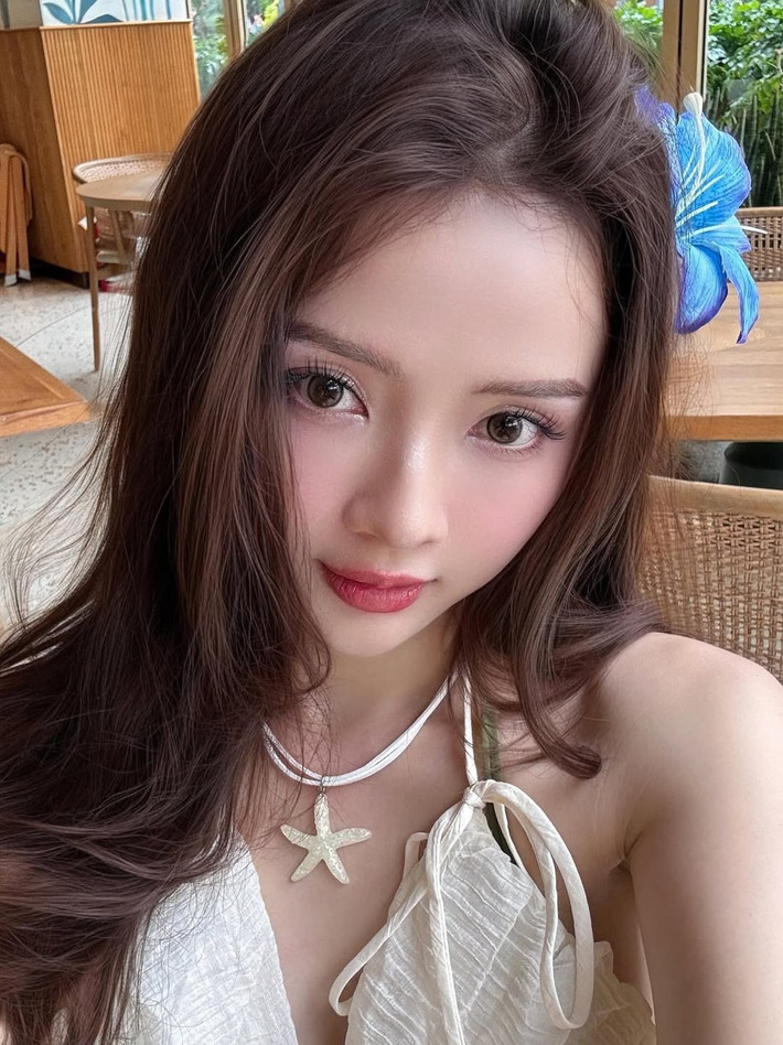 Điểm xuyết cho tổng thể là những phụ kiện tinh tế như vòng cổ hình ngôi sao biển và bông hoa xanh cài trên tóc, mang đến vẻ đẹp dịu dàng, gần gũi với thiên nhiên. (Ảnh: IGNV)