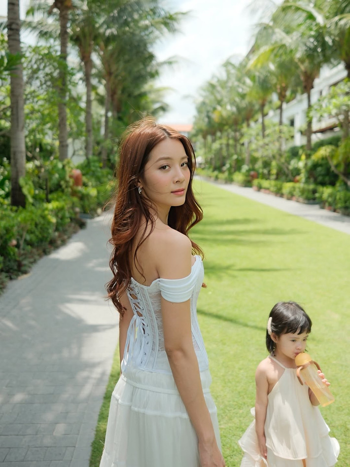 Bé Sophie cũng rất tự nhiên, hồn nhiên, có lúc chỉ tay về phía xa như muốn khám phá thế giới xung quanh, có lúc lại cúi xuống nghịch ngợm.