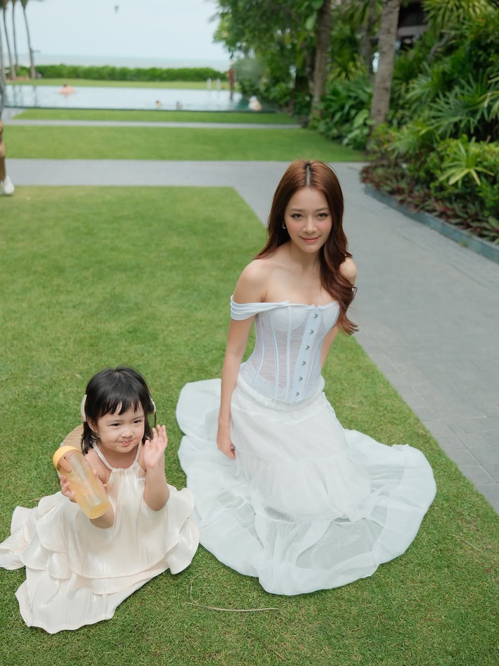 Nữ diễn viên thể hiện sự dịu dàng, ân cần khi nhìn con đầy trìu mến, hay cùng con tham gia các hoạt động đơn giản như nắm tay, ngồi trên thảm cỏ.