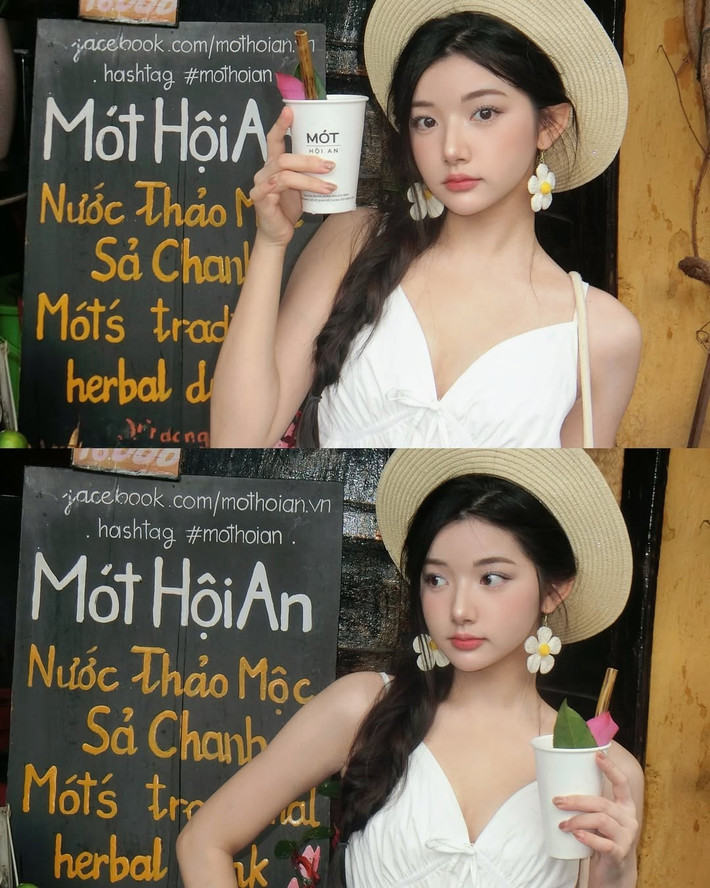 Điểm nhấn là mái tóc tết lệch mềm mại, đôi hoa tai dáng lớn và chiếc túi cói đậm chất mùa hè – tất cả hòa quyện trong khung cảnh Hội An ngập nắng và hoa, khiến cô nàng như một nàng thơ trong truyện tranh.