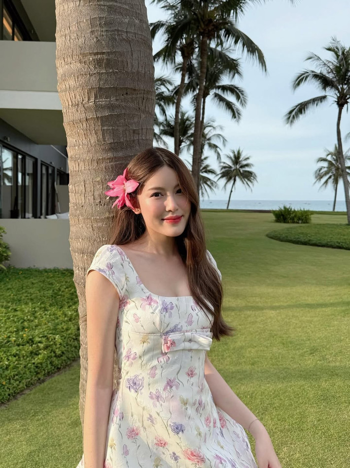 Bên cạnh đôi chân dài "cực phẩm", Tăng Mỹ Hàn vẫn giữ nguyên vẻ đẹp ngọt ngào, trong trẻo thường thấy. Nụ cười mỉm duyên dáng, ánh mắt nhẹ nhàng cùng bông hoa dâm bụt hồng cài trên tóc đã tạo nên một tổng thể hài hòa, tựa như một "nàng thơ" giữa khung cảnh xanh mát của hàng dừa và biển cả.