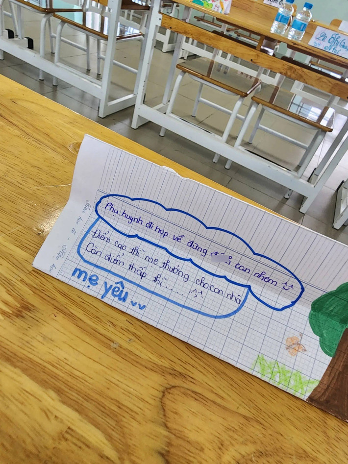 Một lời nhắn khác còn khiến người xem “dở khóc dở cười” hơn: "Phụ huynh đi họp về đừng đánh con nhen. Điểm cao thì mẹ thưởng cho con còn điểm thấp thì..." kèm theo lời lẽ lấy lòng "mẹ yêu". Không chỉ là một tờ giấy viết vội, đây rõ ràng là một “tác phẩm” chuẩn bị kỹ lưỡng, từ lời lẽ đến cảm xúc đều thể hiện sự năn nỉ xen lẫn hài hước của một đứa trẻ đang cố gắng “cứu vớt” tình hình điểm số không mấy sáng sủa.