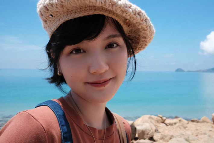 Giữa khung cảnh biển cả mênh mông và ánh nắng dịu nhẹ, Hải Tú khoe nụ cười tươi tắn, ánh mắt long lanh đầy sức sống. Gương mặt thanh tú cùng mái tóc ngắn đặc trưng càng làm nổi bật vẻ đẹp trong sáng, không tì vết của cô.