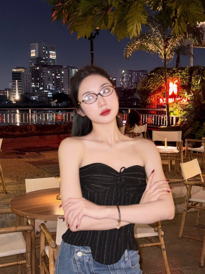Mái tóc dài được búi nửa đầu gọn gàng, để lộ gương mặt thanh tú, kết hợp cùng lối trang điểm sắc sảo, nhấn vào đôi môi đỏ mọng, càng làm tăng thêm vẻ cuốn hút.