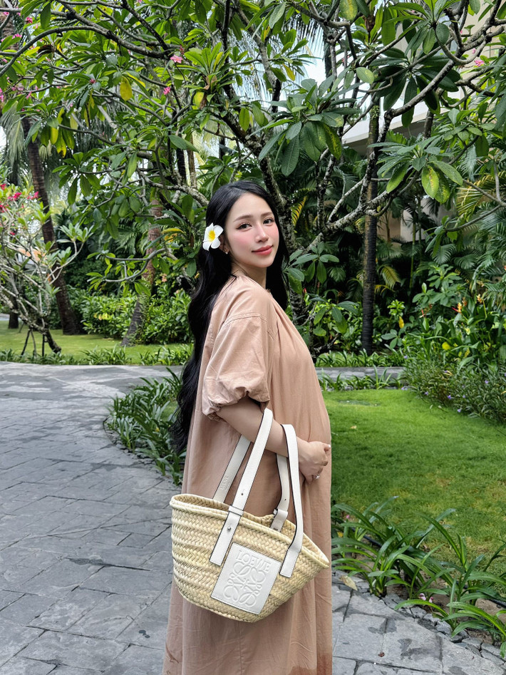 Bên cạnh những thiết kế khá "bánh bèo", cô nàng cũng lựa chọn lối lên đồ nhã nhặn, giản đơn. Chiếc váy maxi dáng suông màu be nhã nhặn, phối cùng túi cói Loewe thời thượng, mang đến sự thoải mái nhưng không kém phần sang trọng.