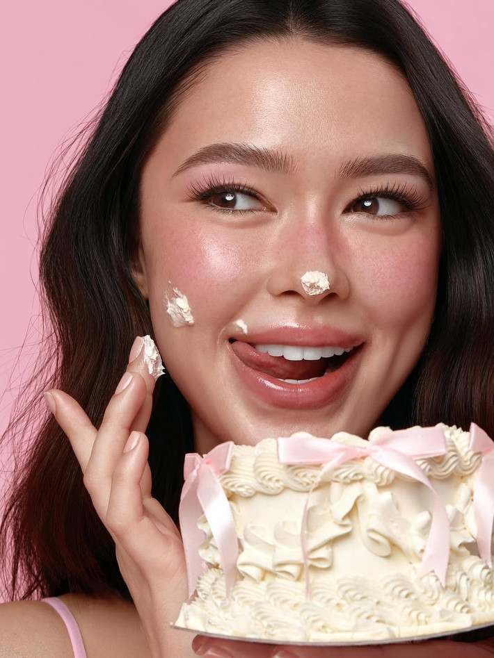 Cô nàng tạo dáng tinh nghịch bên chiếc bánh kem nhỏ xinh, thậm chí còn không ngại làm mặt xấu với kem dính trên mũi, một hình ảnh vô cùng đáng yêu và gần gũi. (Ảnh: IGNV)