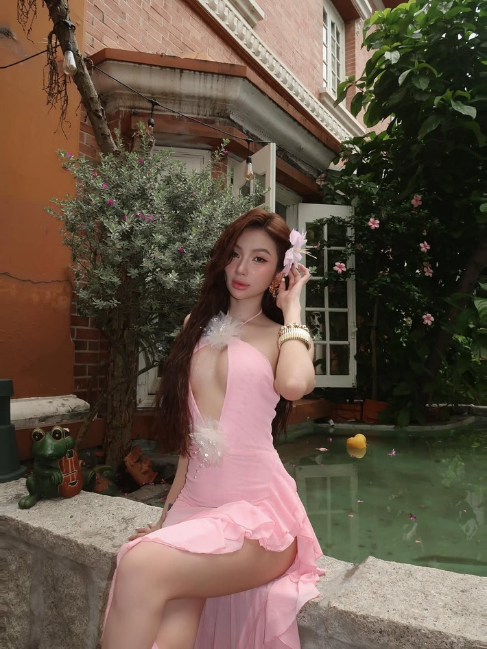 Phần cổ yếm cùng những lớp bèo nhún mềm mại bất đối xứng tạo nên sự bay bổng, lãng mạn, đồng thời tăng thêm vẻ quyến rũ cho trang phục.