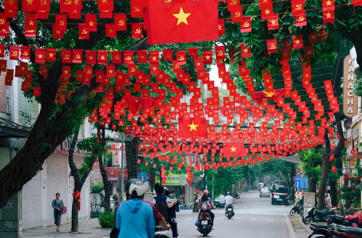 Những dải cờ đỏ nối tiếp nhau, đan xen giữa những tán cây xanh mát, tạo thành một "mái vòm" cờ rực rỡ. (Ảnh: Blog Của Rọt)