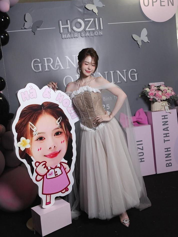 Cô cũng không quên tạo dáng nhí nhảnh bên mô hình chibi dễ thương của chính mình, thể hiện sự vui tươi và gần gũi.