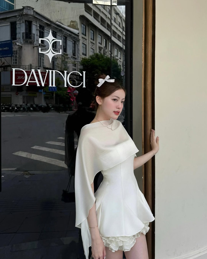 Điểm nhấn trong outfit này chính là phụ kiện nơ trắng cài tóc, khiến tổng thể hài hòa một cách tinh tế.