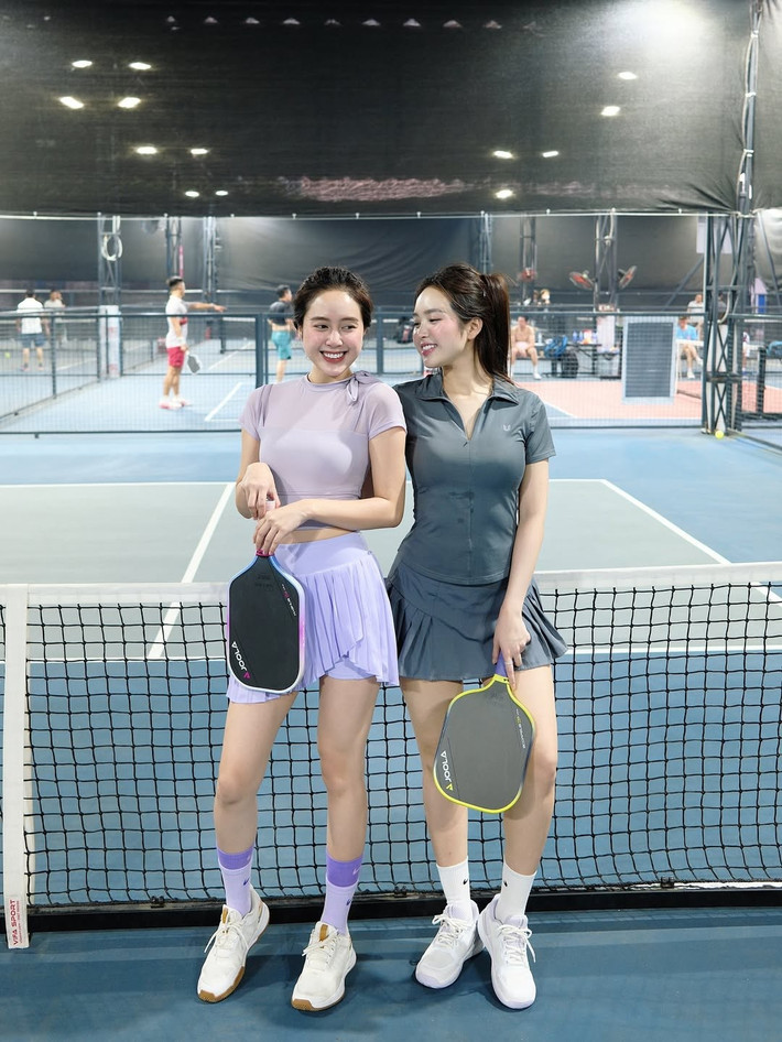 Mái tóc dài được buộc gọn gàng kiểu đuôi ngựa, vừa tiện lợi khi di chuyển vừa giúp cô khoe trọn gương mặt thanh tú, rạng rỡ với nụ cười tươi tắn.