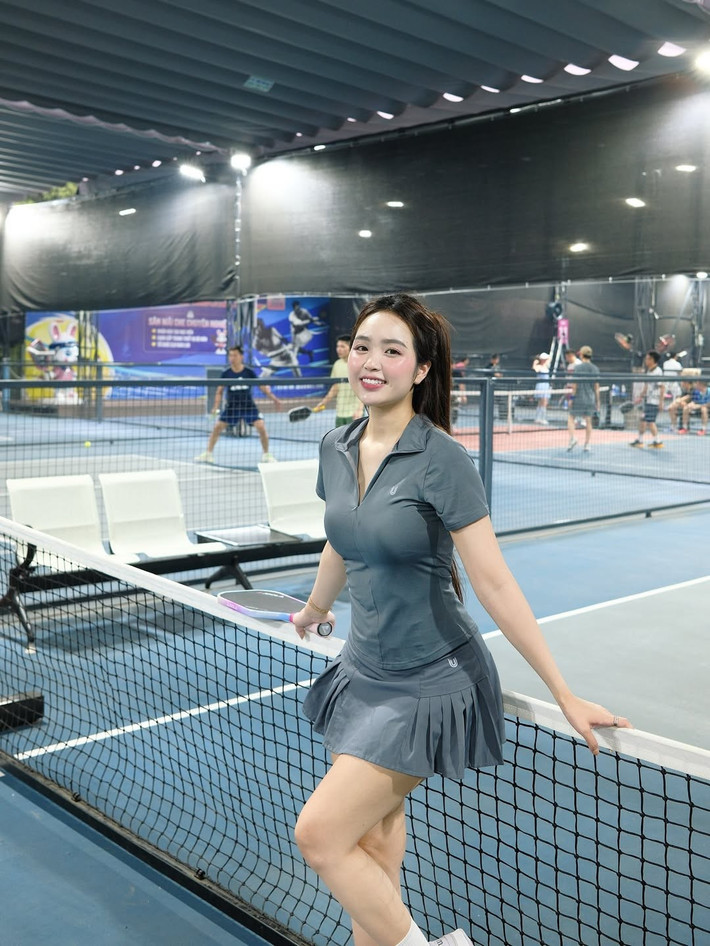 Điểm nhấn của trang phục là chiếc áo polo có khóa kéo cổ V, mang lại vẻ trẻ trung và hiện đại. Cô nàng kết hợp với đôi giày thể thao trắng cùng tất cao cổ, tạo nên một tổng thể hài hòa và đúng chất dân thể thao.