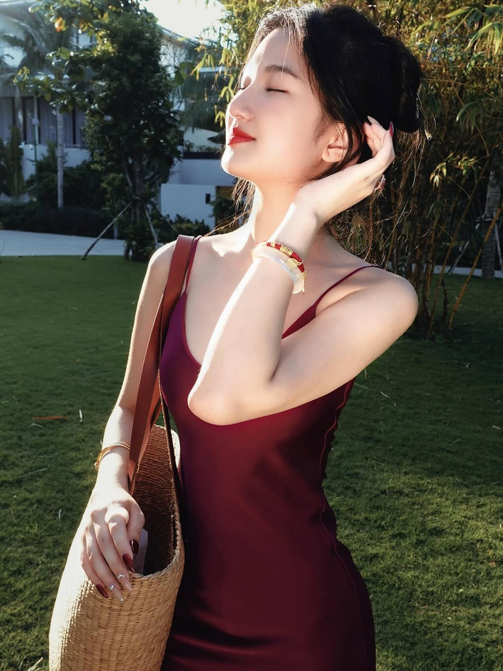 "Nàng mơ" tự tin tạo dáng giữa không gian tràn ngập sắc xanh của cây lá và những chùm hoa giấy màu hồng rực rỡ. Ánh nắng nhẹ nhàng hắt lên làn da trắng sáng, tạo nên một hiệu ứng lung linh, huyền ảo.
