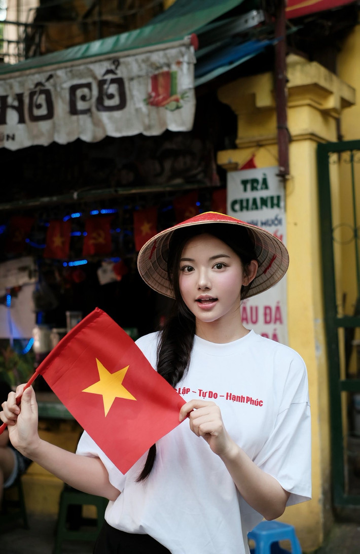 Trong loạt ảnh mới, Quỳnh Trương xuất hiện giản dị nhưng vẫn nổi bật. Diện chiếc áo phông trắng với dòng chữ “Độc Lập – Tự Do – Hạnh Phúc” và chiếc nón lá truyền thống, cô khoe vẻ đẹp thanh thoát, thuần Việt. (Ảnh: FBNV)