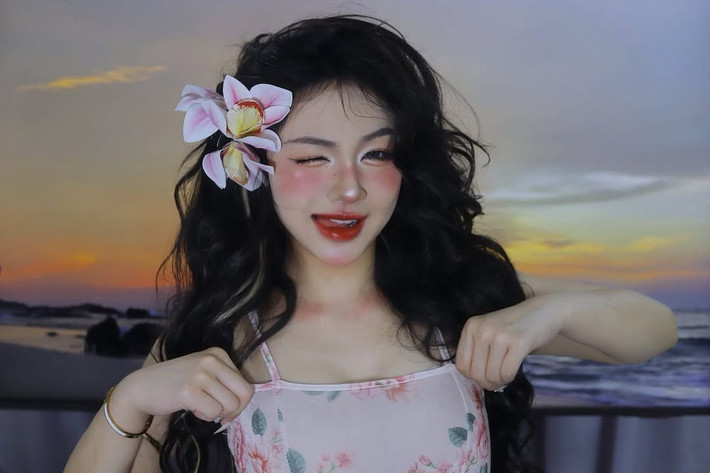 Mái tóc dài xoăn nhẹ tự nhiên, được thả xõa và cài thêm những bông hoa phong lan trắng hồng tinh tế, tăng thêm vẻ nữ tính và lãng mạn. Phụ kiện đi kèm khá tối giản, có thể thấy vòng tay và khuyên tai nhỏ nhắn, không quá cầu kỳ để tôn lên tổng thể trang phục và make-up.