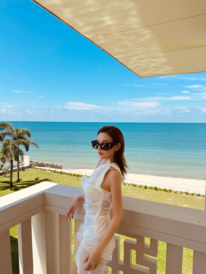Khung cảnh biển xanh – nắng vàng phía sau như được "nâng tầm" nhờ sự xuất hiện của Huyền Baby. Ánh sáng tự nhiên phản chiếu nhẹ nhàng trên làn da trắng sứ của cô, khiến mọi khung hình đều toát lên cảm giác của một kỳ nghỉ xa hoa nơi resort 5 sao.