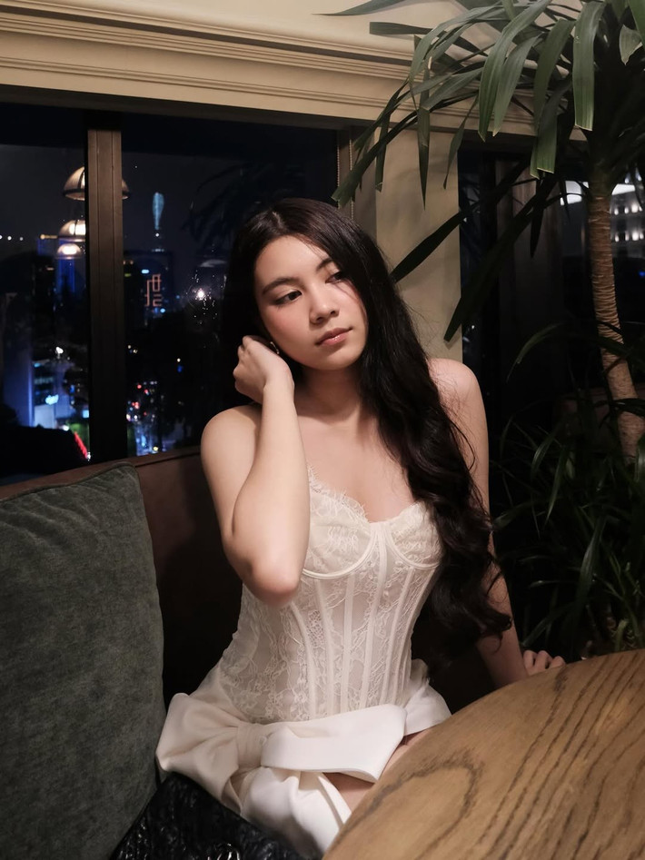 Thiết kế váy ngắn cách điệu làm nổi bật đôi chân thon dài, kết hợp cùng mái tóc đen dài bồng bềnh, tạo nên một tổng thể vừa ngọt ngào, vừa sang trọng.