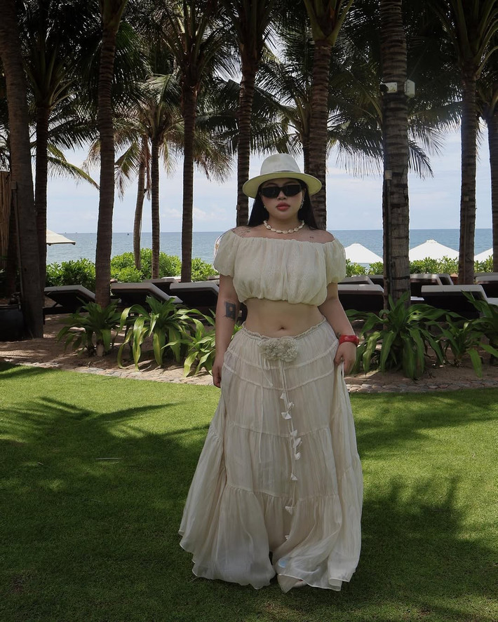 Xuất hiện với outfit lấy cảm hứng từ thời trang Boho cổ điển, Hữu Vi diện chiếc crop top trễ vai kết hợp chân váy dài tầng màu kem nhạt – set đồ không chỉ tôn lên đường cong đặc trưng mà còn phô diễn nét phóng khoáng, đầy tự tin của cô nàng.