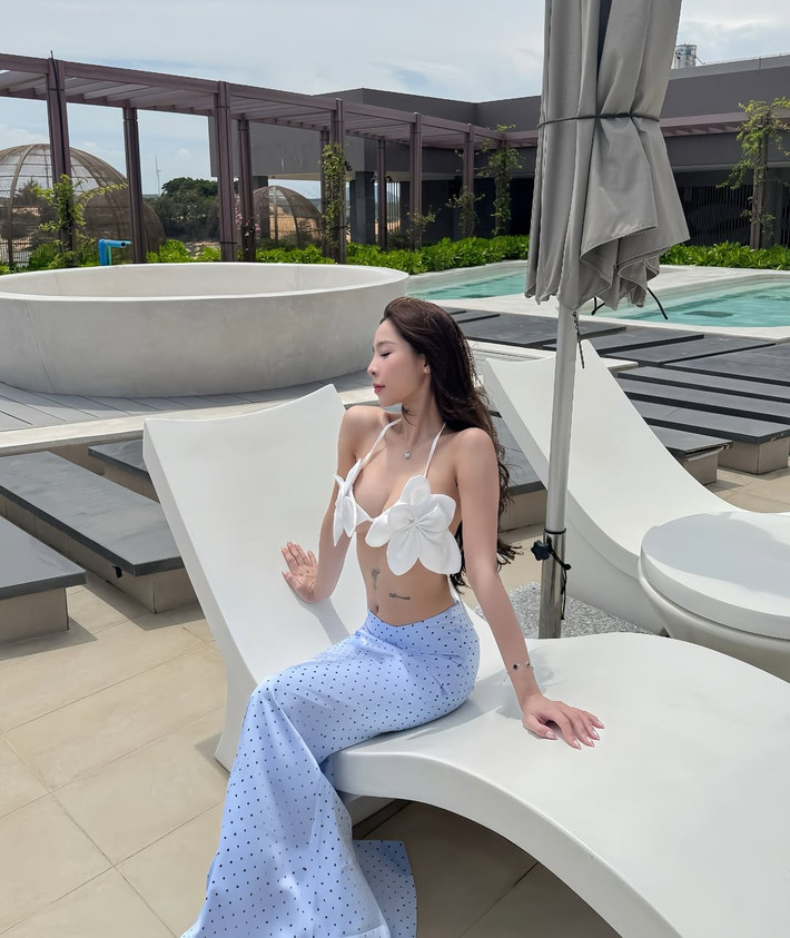 Kết hợp cùng chiếc áo bikini hoa, Tammy Phạm lựa chọn một chiếc chân váy màu xanh nhạt với họa tiết chấm bi nhỏ nhắn, ton-sur-ton với sắc trời và màu nước biển. (Ảnh: IGNV)