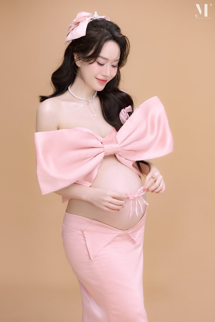 Sắc hồng pastel được sử dụng xuyên suốt trong trang phục, phụ kiện và bối cảnh tạo nên tổng thể nhẹ nhàng, ngọt ngào như một bản tình ca dành cho em bé sắp chào đời.
