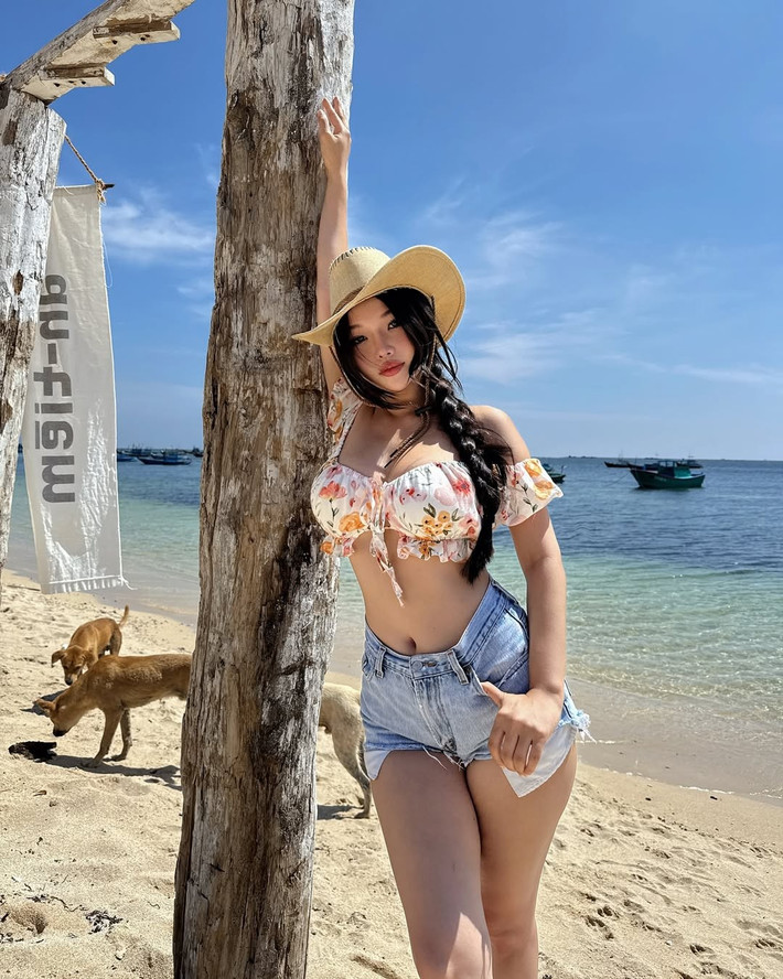 Chiếc mũ cao bồi và ly nước mát lạnh càng làm tăng thêm sự phóng khoáng và thoải mái của trang phục dạo biển.