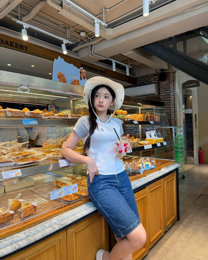 Quỳnh Trương diện áo thun ôm body tay raglan phối xám, quần jean lửng và một chiếc nón rộng vành – outfit “bình thường” đến mức không ai nghĩ nó sẽ viral. Thế nhưng, chính vẻ tự nhiên, năng động, pha chút e ấp trong ánh mắt và nụ cười lại khiến người xem như bị “dính bùa”.