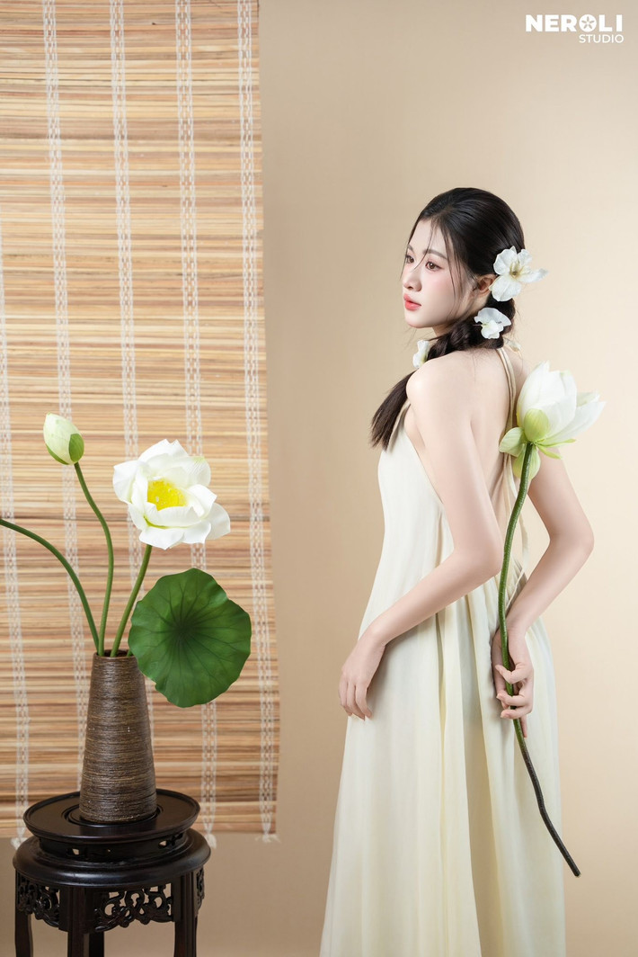 Kiểu tóc tết đơn giản được cài thêm những bông hoa ngọc lan trắng muốt, tạo nên một tổng thể hài hòa, mang đậm hơi thở của vẻ đẹp Việt truyền thống.