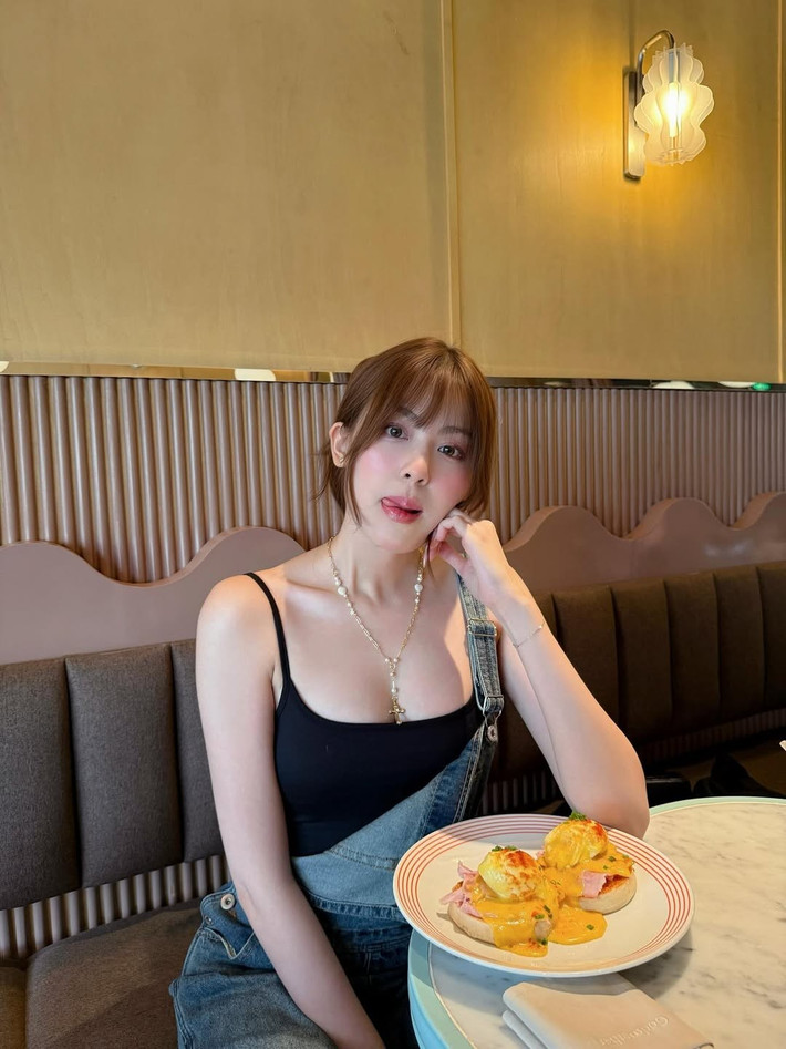 Cô nàng diện quần yếm denim ống rộng, kết hợp bên trong là áo tank top đen đơn giản. (Ảnh: FBNV)