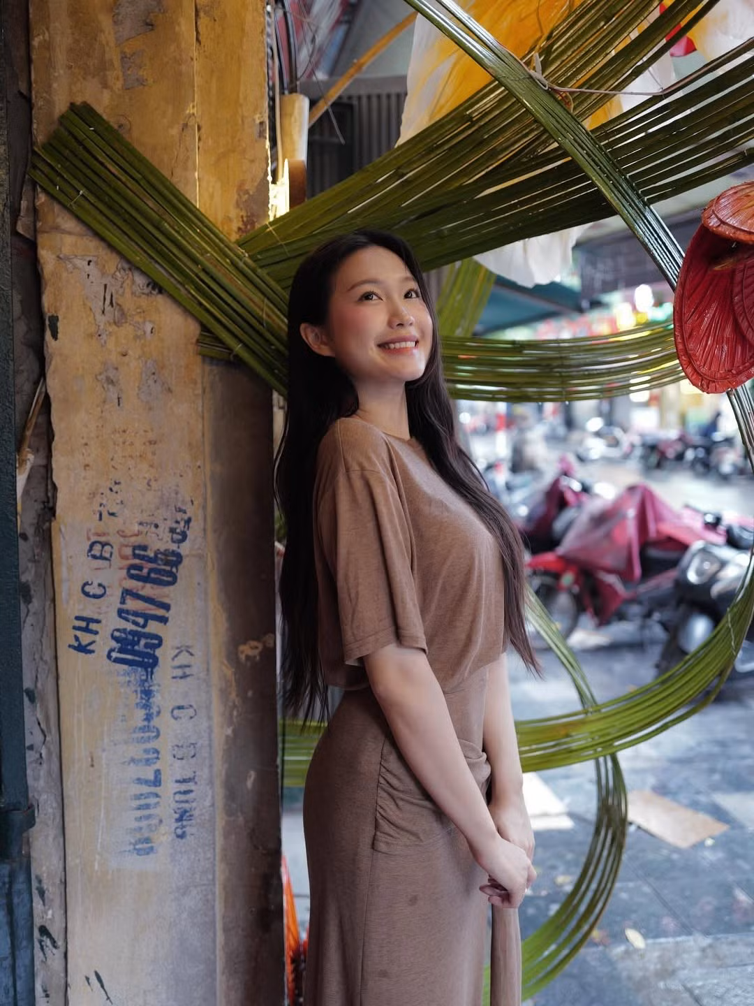 Dù là ngồi nghỉ ngơi bên bức tường vàng cổ kính của Hà Nội hay tạo dáng bên những vật trang trí đậm chất truyền thống, Doãn Hải My vẫn tỏa sáng một cách tự nhiên. (Ảnh: IGNV)