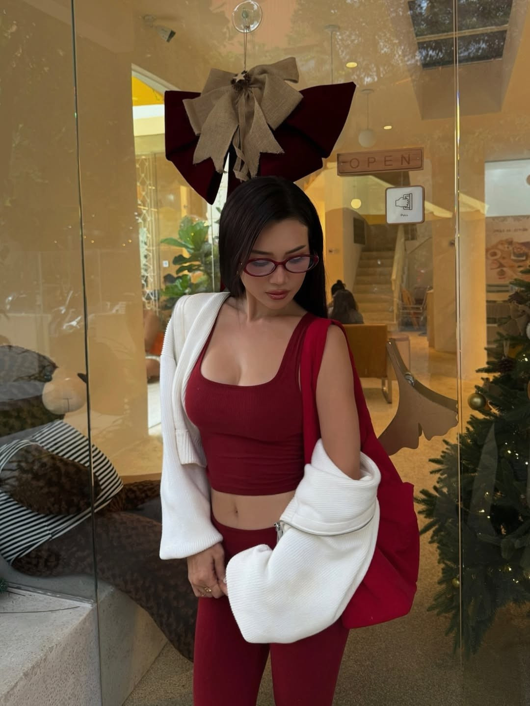 Chiếc kính gọng đỏ thời trang không chỉ giúp bảo vệ đôi mắt mà còn hoàn thiện vẻ ngoài hiện đại, cá tính của nữ nghệ sĩ. (Ảnh: IGNV)