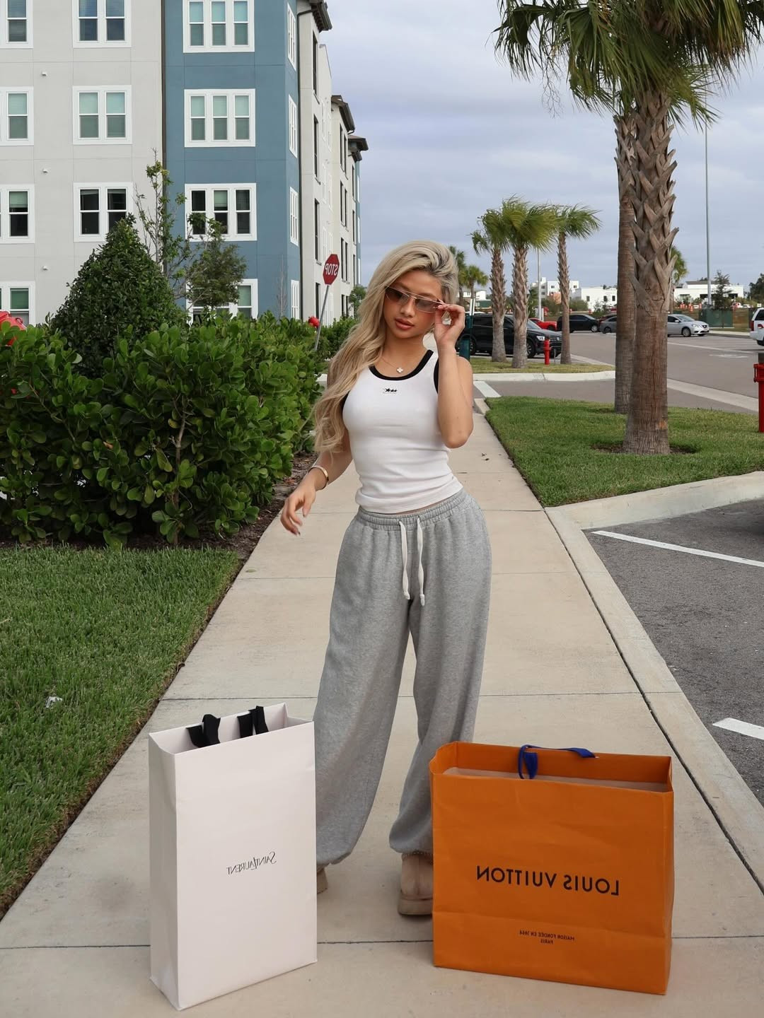 Cựu vận động viên thể dục dụng cụ chọn cho mình phong cách streetwear thoải mái với áo tank-top ôm sát, quần nỉ ống rộng và giày bệt. Điểm nhấn của bộ trang phục chính là chiếc kính mát thời thượng và mái tóc bạch kim nổi bật. (Ảnh: IGNV)