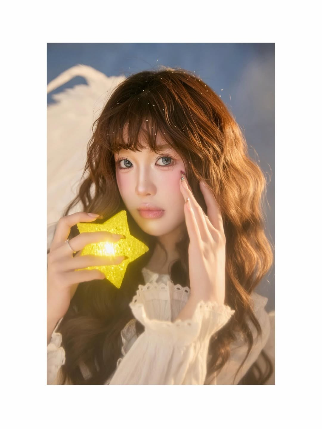 Không gian studio được dàn dựng công phu với lớp bông trắng bồng bềnh như mây, kết hợp cùng ánh sáng vàng ấm áp tạo nên một khung cảnh lung linh, mộng mị. Mỗi khung hình đều toát lên vẻ thanh khiết, khiến người xem như đang lạc vào một câu chuyện cổ tích hiện đại. (Ảnh: IGNV)