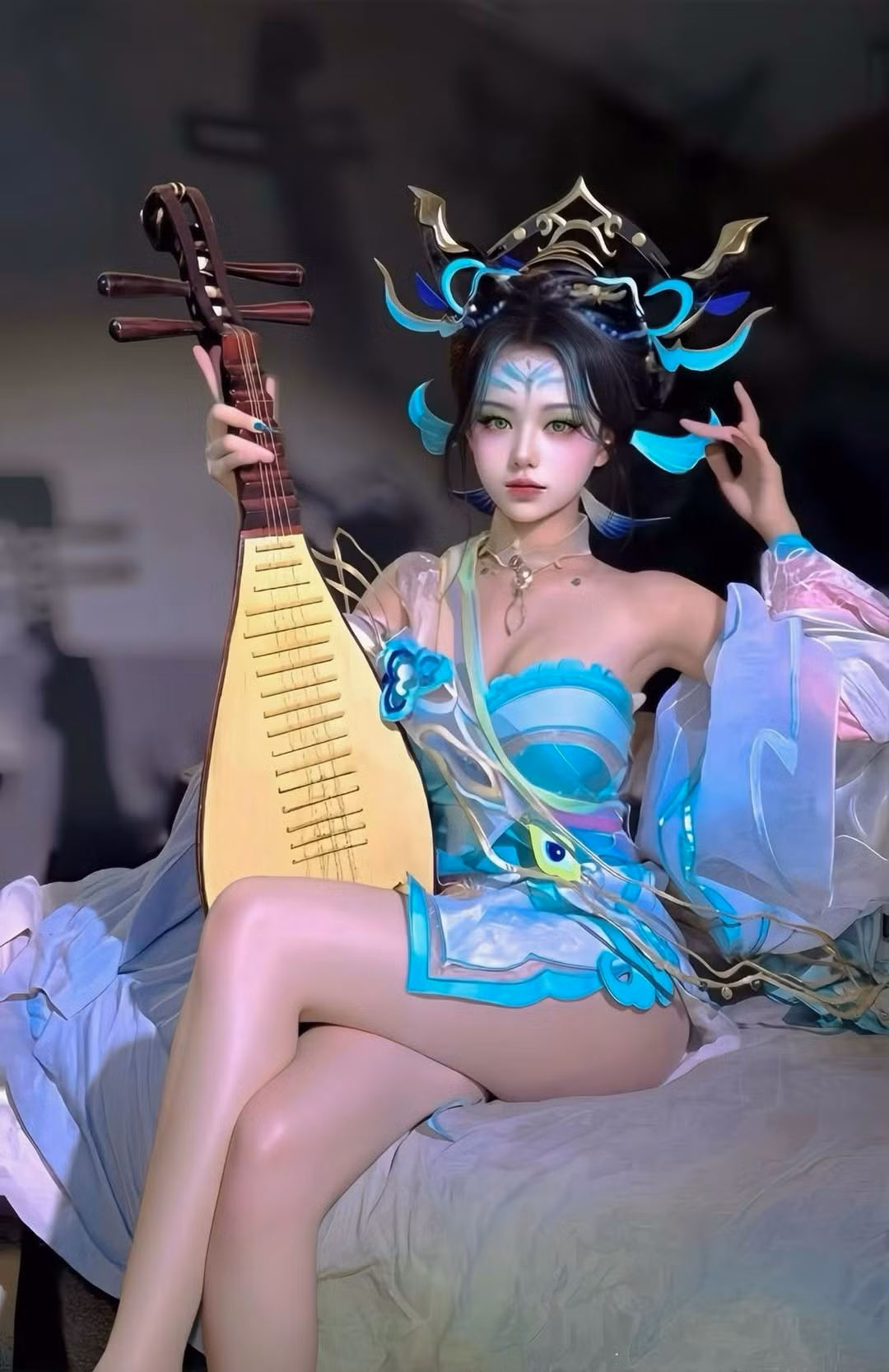 Cô nàng cực kỳ đầu tư vào chi tiết với tông màu xanh ngọc chủ đạo, kết hợp cùng các dải lụa mềm mại và phụ kiện vàng ánh kim tinh xảo. Điểm nhấn là chiếc mũ đội đầu với họa tiết cánh phượng, giúp tái hiện hoàn hảo khí chất của một "Nữ vương bóng đêm" nhưng nay đã mang dáng dấp của một tiên nữ cao sang. (Ảnh: FBNV)