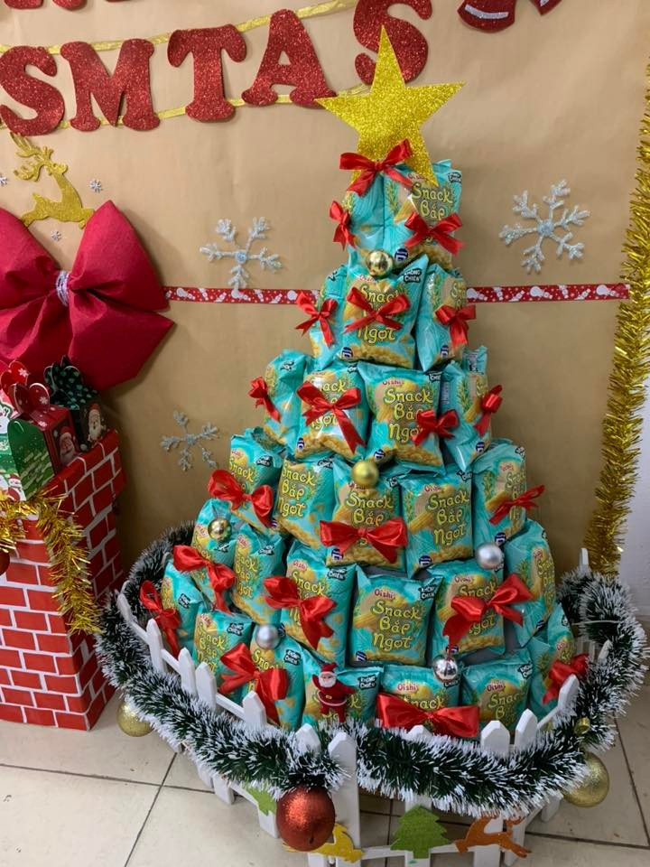 Xếp từ các gói bánh snack, trang trí nơ đỏ và châu nhỏ. Đây là cây thông lý tưởng để trang trí trong các trường học, văn phòng hoặc góc giải trí tại gia, vừa đẹp mắt lại vừa có thể "hóa giải" ngay sau khi mùa lễ kết thúc.