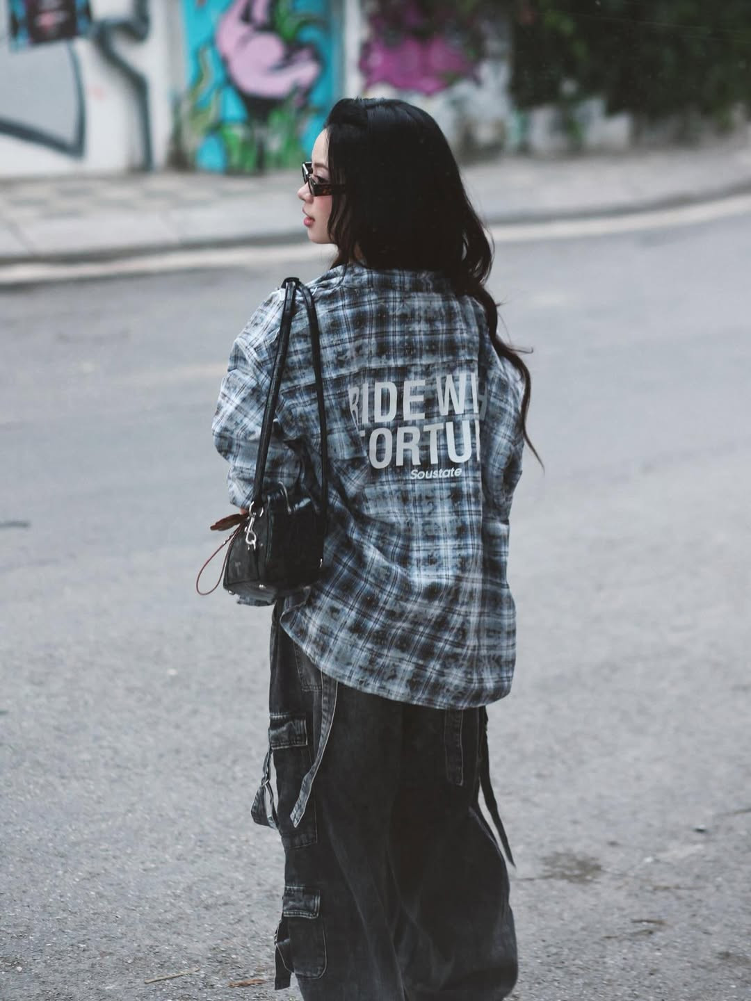 Chiếc áo sơ mi kẻ caro khoác hờ bên ngoài cùng quần denim ống rộng cạp trễ không chỉ tạo nên vẻ ngoài bụi bặm, cá tính mà còn khéo léo khoe được vòng eo phẳng lì - niềm mơ ước của biết bao bà mẹ bỉm sữa. (Ảnh: IGNV)