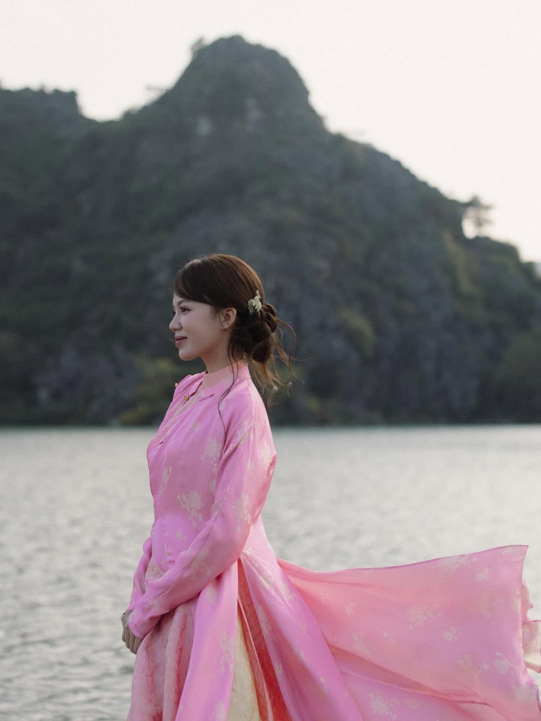 Điểm nhấn đặc biệt nhất của bộ ảnh chính là những khung hình được chụp vào lúc hoàng hôn. Dưới ánh nắng vàng ruộm cuối ngày, bóng dáng của nàng TikToker đổ dài bên bờ đá, tạo nên một cảm giác yên bình và có chút hoài cổ. (Ảnh: IGNV)