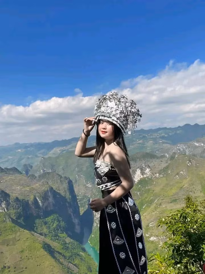 Nhắc đến Mua Thị Dua, cộng đồng mạng sẽ nhớ ngay đến hình ảnh cô bé dân tộc H'Mông với nụ cười tươi rói, đôi môi hồng tự nhiên và gương mặt bầu bĩnh, đáng yêu, đeo gùi hoa đứng bên dốc Thẩm Mã (Hà Giang) vào năm 2019. (Ảnh: FBNV)